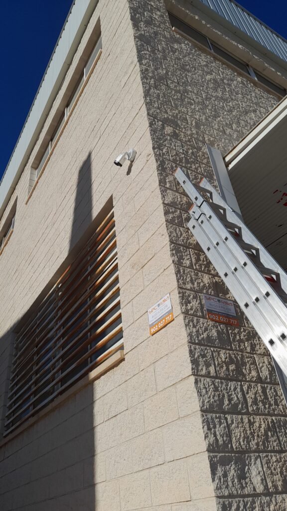 Cámara de videovigilancia instalada en fachada de nave